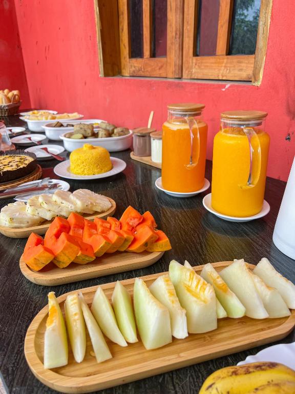 une table avec des assiettes de fruits et des bocaux de jus dans l'établissement Pousada Sempre Viva Lençóis, à Lençóis