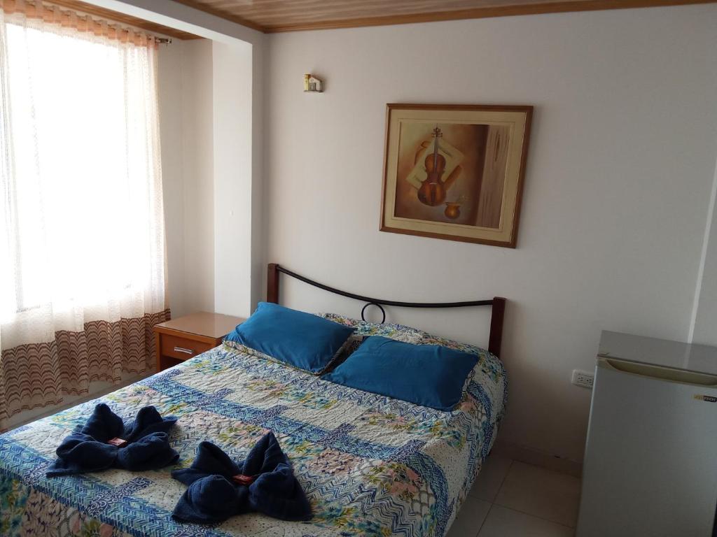 ein Schlafzimmer mit einem Bett mit blauen Kissen darauf in der Unterkunft Casa Bercel in Choachí