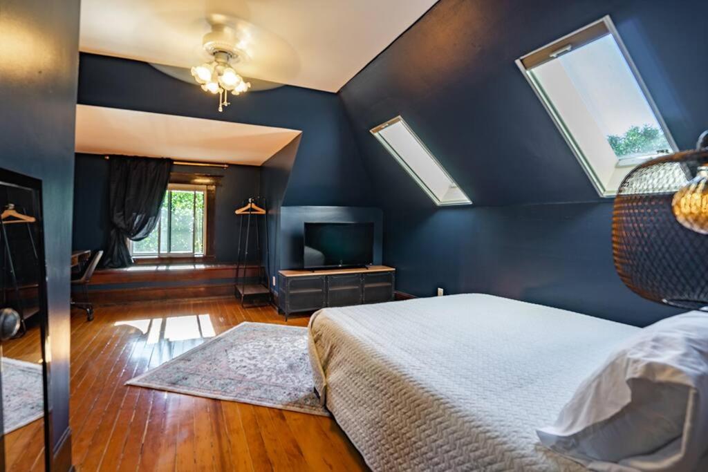 a bedroom with blue walls and a bed and a tv at Charming Room in Capitol Hill - Foxglove Inn Rm 8 in Seattle