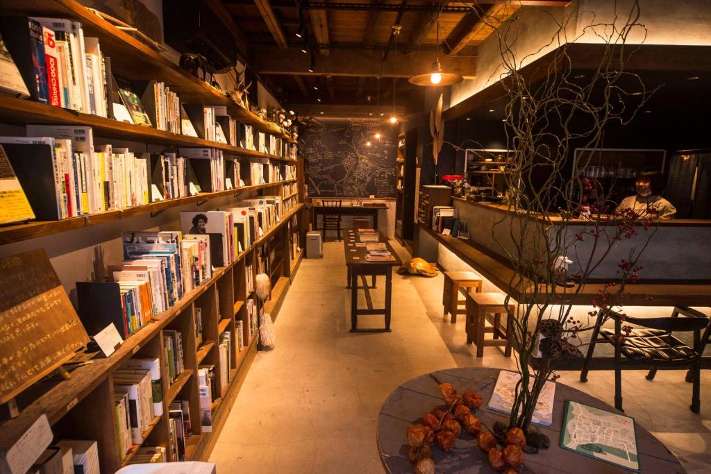 a library filled with lots of books on shelves at Book & Guesthouse Hitotomaru in Toyooka