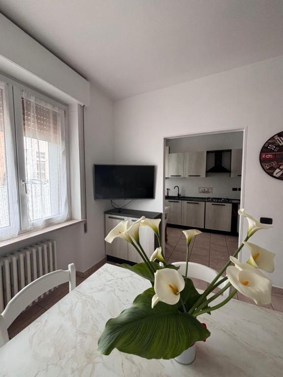 uma sala de estar com um vaso de flores sobre uma mesa em Casa Bardolina - Baia Flaminia em Pesaro