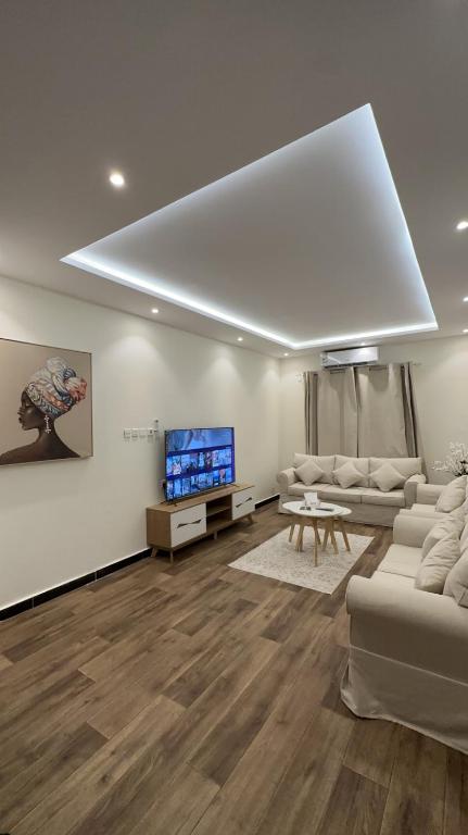sala de estar con sofá y TV de pantalla plana en غرفه وصاله بدخول ذاااتي, en Riad