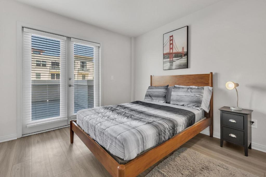 a bedroom with a bed and two windows at Spacious two bedroom one bath In Little Italy in San Diego