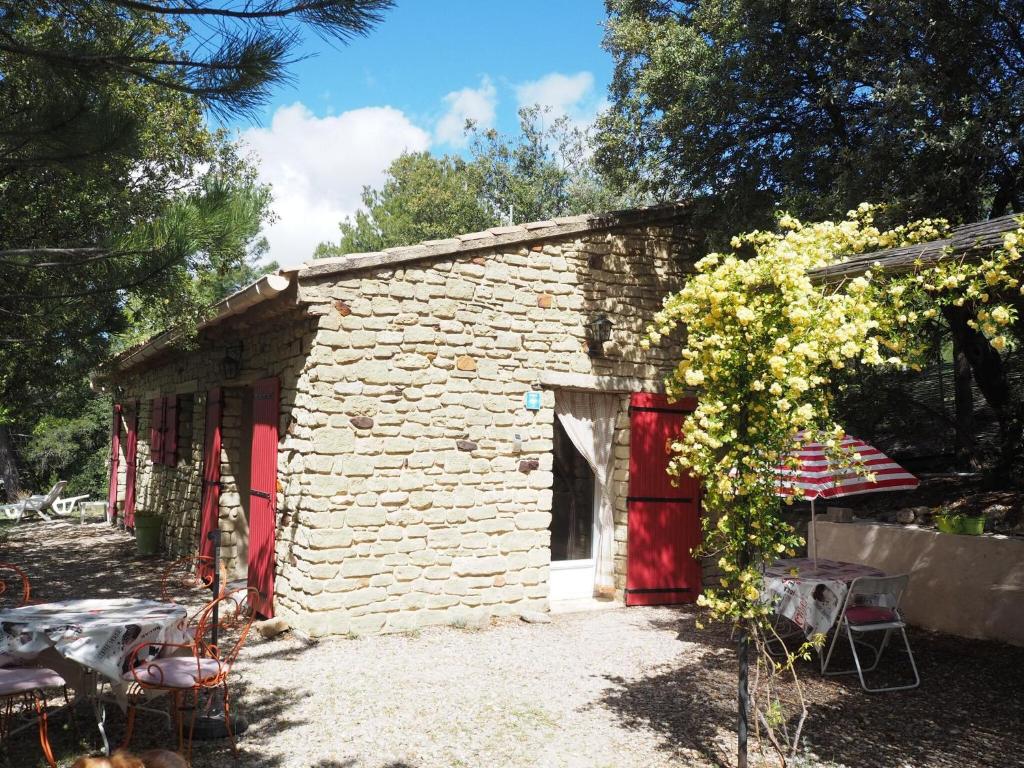 un pequeño edificio de piedra con una puerta roja en holiday home, Bédoin, en Bédoin