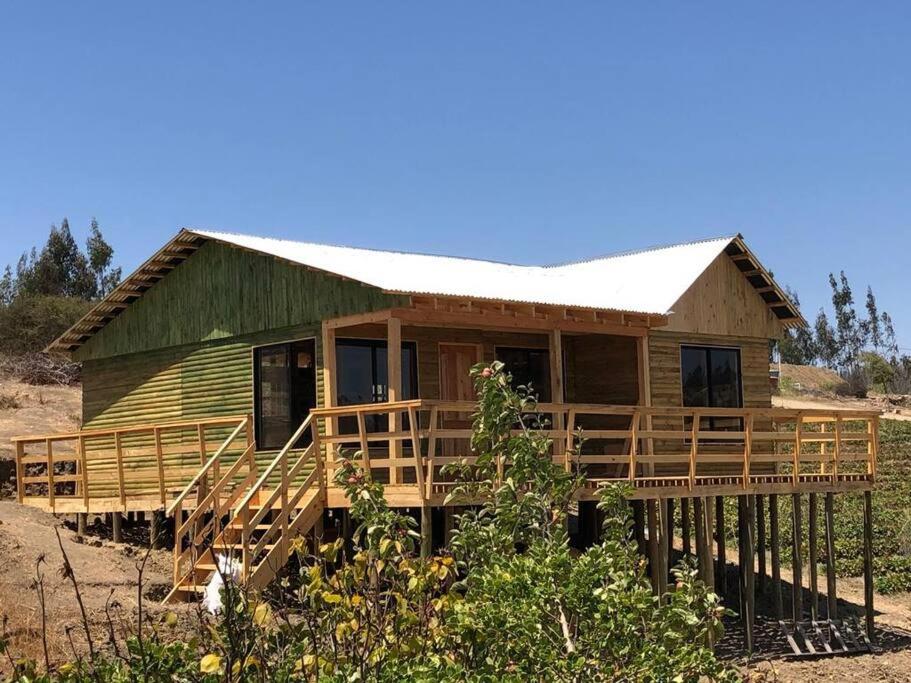 een klein huis met een groen dak op een veld bij Acogedora Cabaña in Cartagena