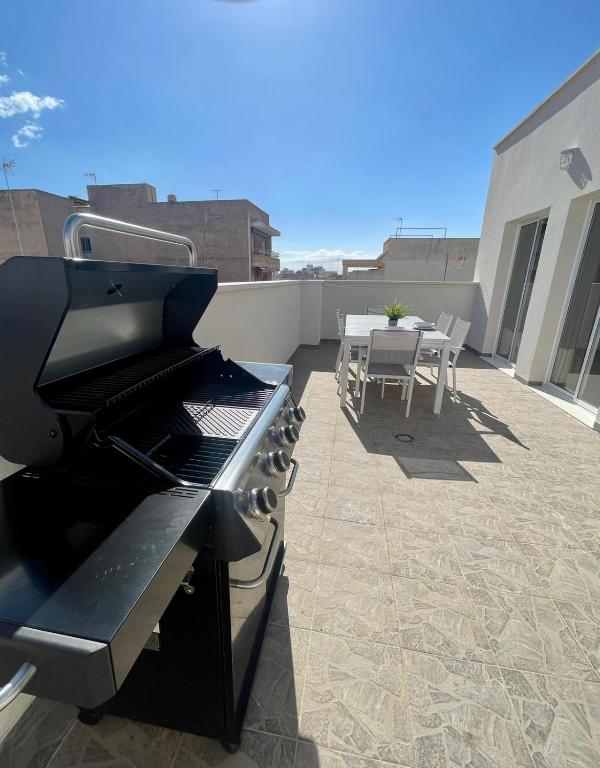 een patio met een grill en een tafel op een dak bij UIM Mediterraneo ATICO Cendoya Wifi in Puerto de Sagunto