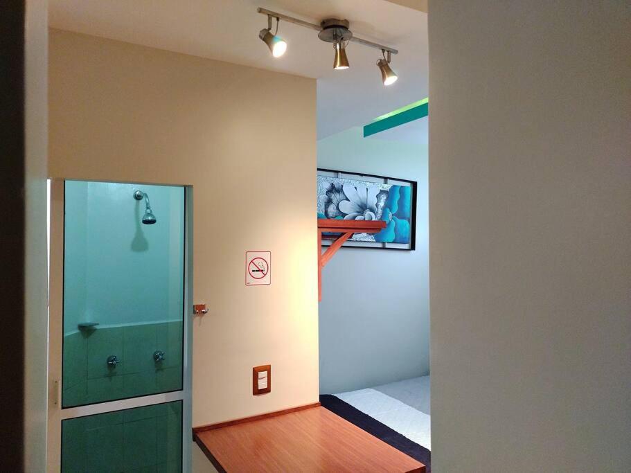 a hallway with a walk in shower and a bathroom with a glass door at bonito mini depto. equipado Futurista in Atlacomulco de Fabela