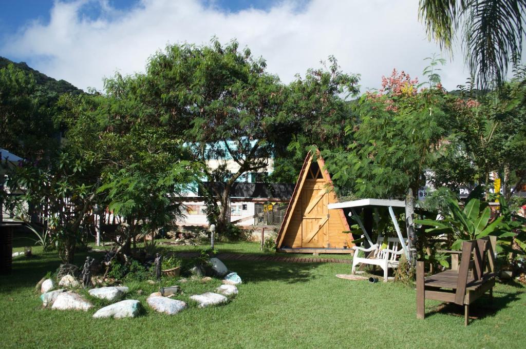 un groupe de moutons pondant dans l'herbe près d'un arbre dans l'établissement HOSTEL BARRA BAR, à Balneário Camboriú