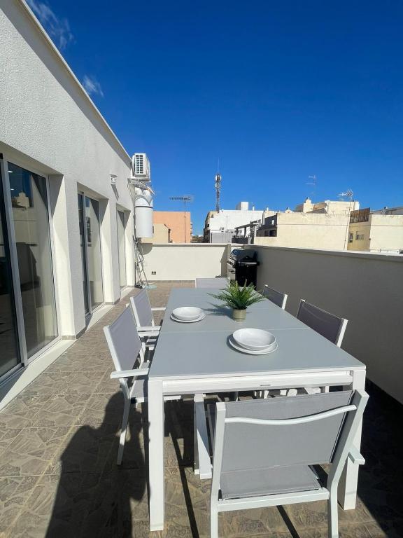 a white table and chairs on a balcony at UIM Mediterraneo ATICO Cendoya Wifi in Puerto de Sagunto