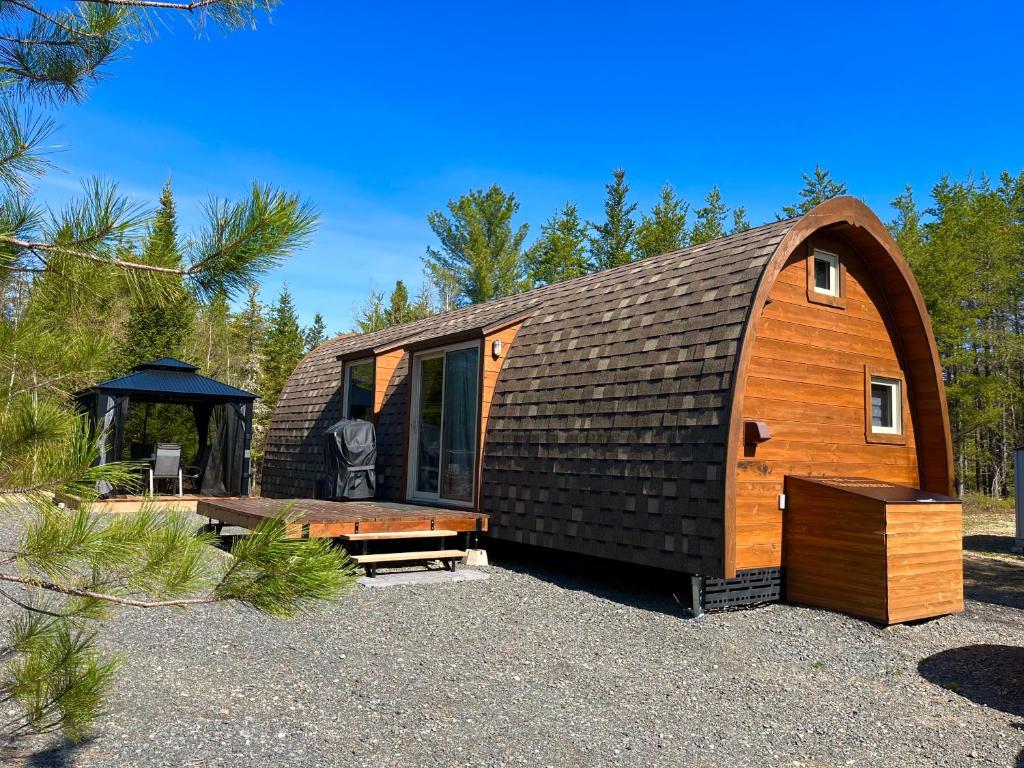 Cabaña de madera pequeña con techo negro en Le POD'Stress / Nature et tranquilité en Saint-Alexis-des-Monts