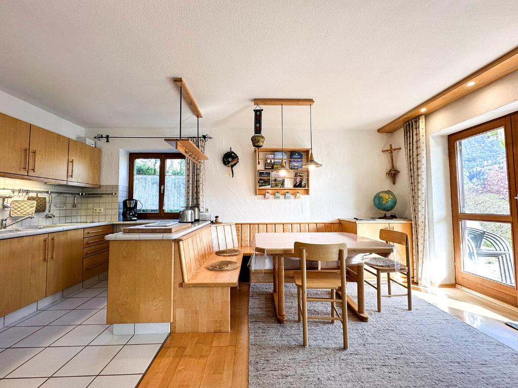 a kitchen with a wooden table and a dining room at FEWO Elsa in Oberstaufen