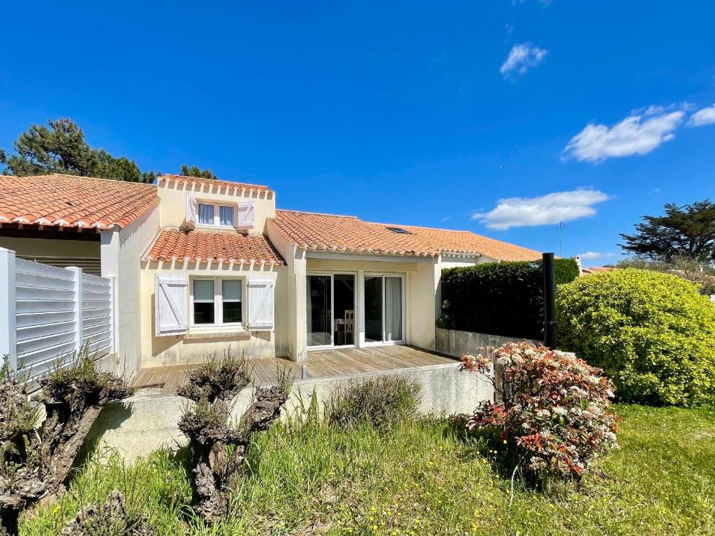 une petite maison blanche avec un porche dans l'établissement Maison Confortable près de la Plage, Terrasse et Équipements Modernes, Calme - Brétignolles-sur-Mer - FR-1-231-61, à Bretignolles-sur-Mer