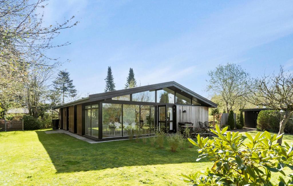 a modern house with glass doors on a yard at Stunning Home In Gilleleje With Wifi in Gilleleje