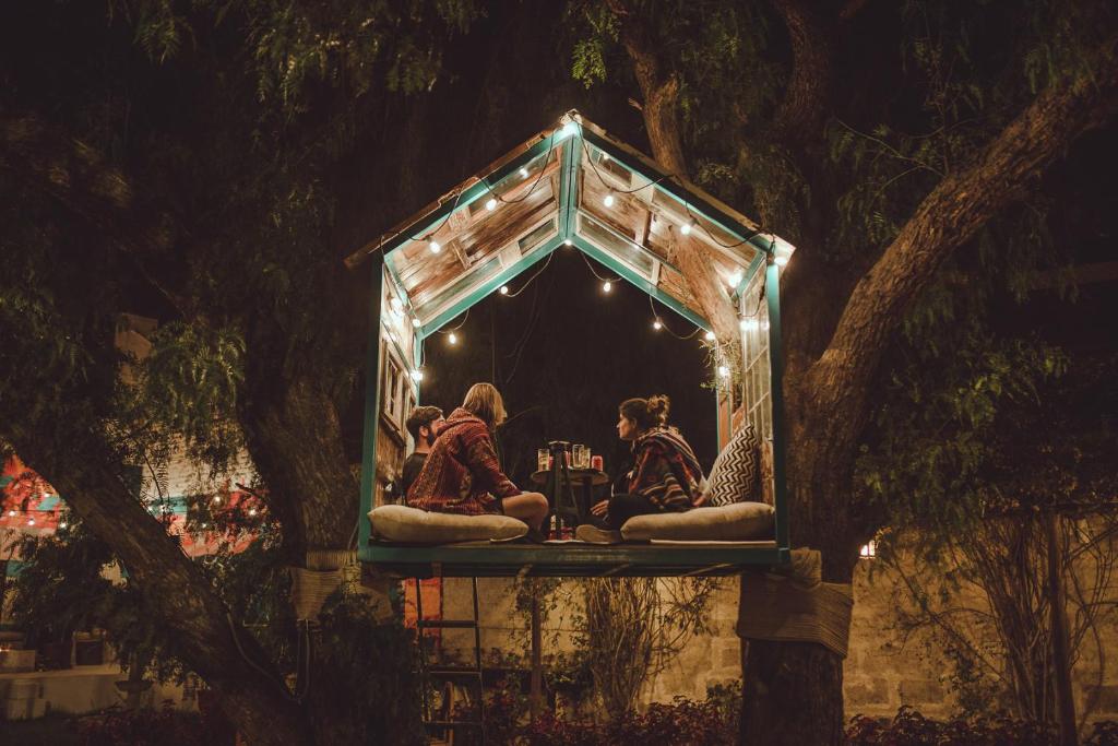 un grupo de personas sentadas en un banco bajo un árbol en Selina Arequipa, en Arequipa