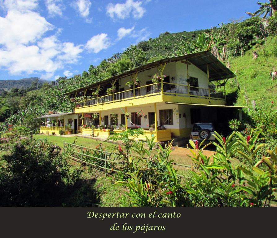 una gran casa amarilla en una colina con una montaña en Alojamiento Rural Jardín Consentido, en Jardín