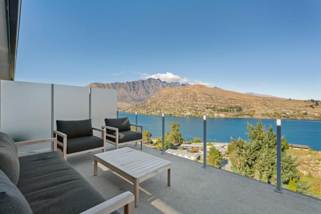 een woonkamer met uitzicht op het water bij Views On The Top - Queenstown Holiday Home in Queenstown