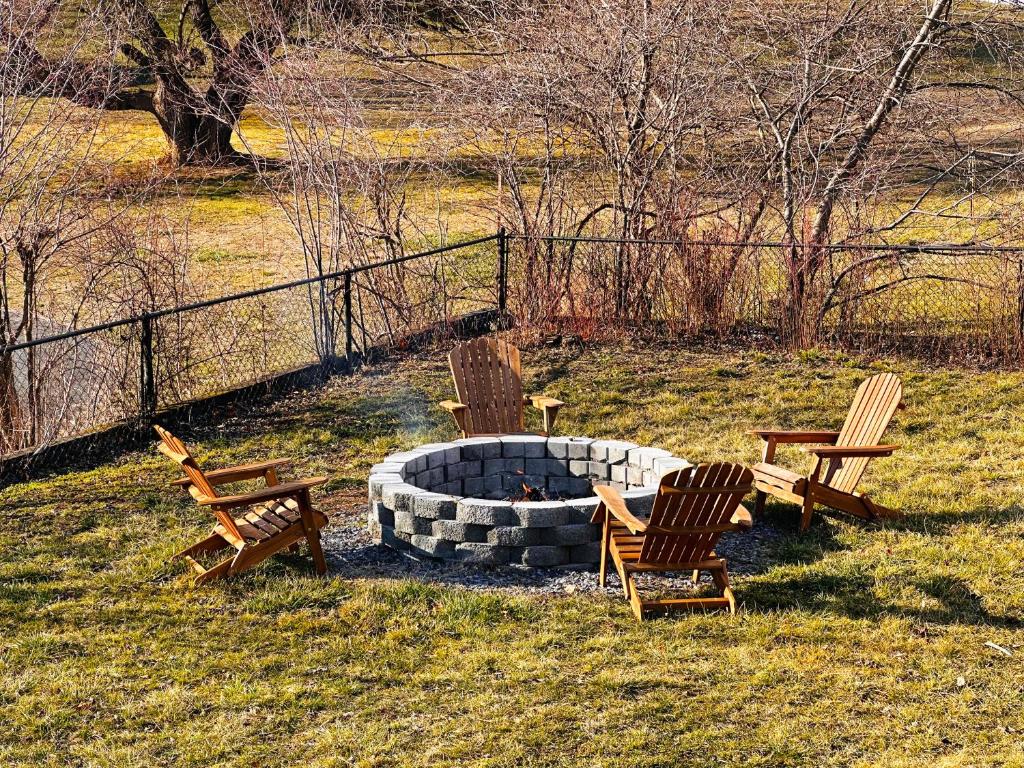 a group of chairs sitting around a fire pit at All Seasons Cottage - Game Room - Firepit By Zen Living Short Term Rental in Luray