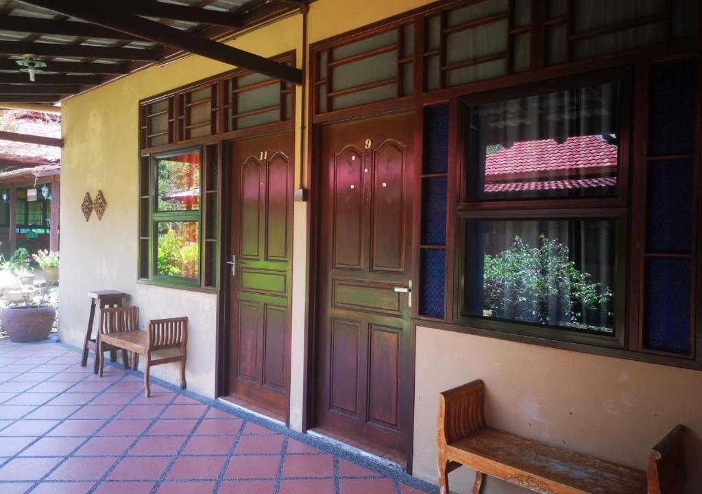 un edificio con puertas de madera y bancos en un patio en Al Sakinah Resort en Bentong