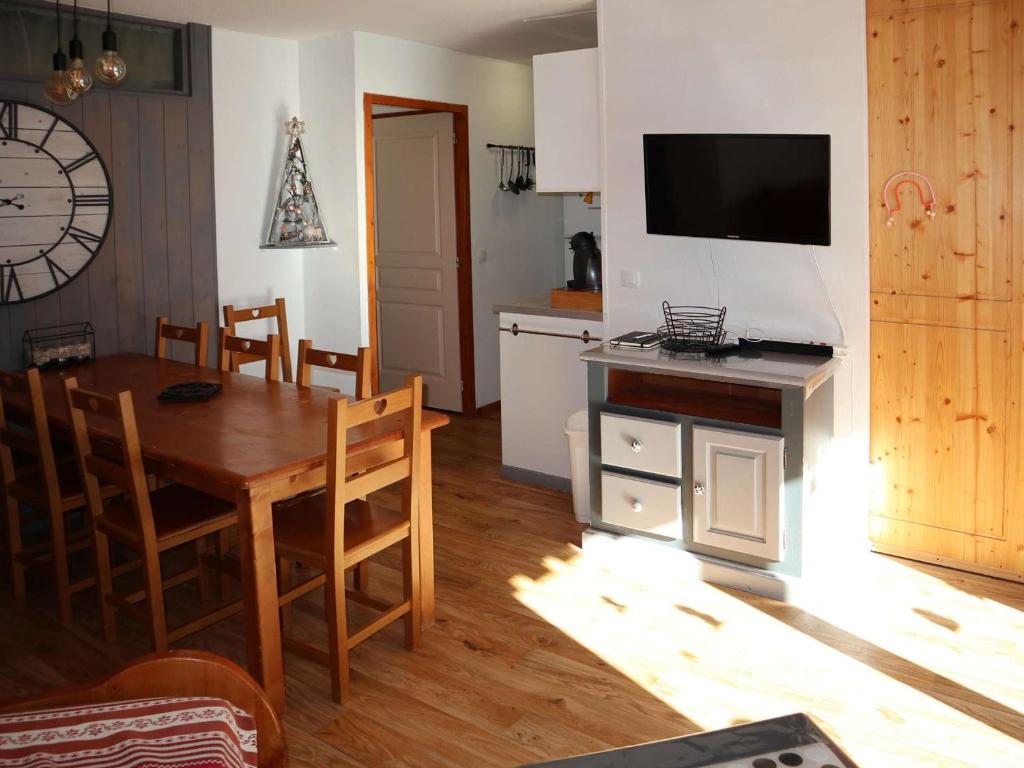 une cuisine et une salle à manger avec une table et une télévision dans l'établissement Les Orres 1800 - Grand appart 3 pièces, 8 pers, piscine chauffée, sauna - FR-1-322-605, aux Orres