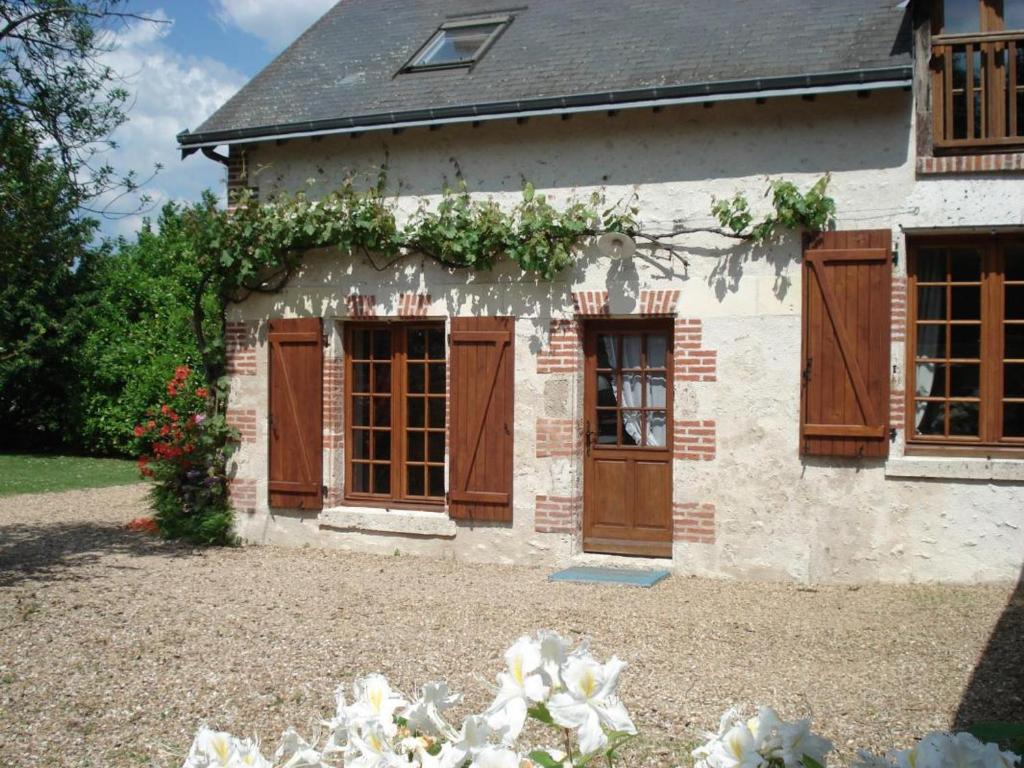a building with wooden doors and flowers on it at Gîte Cheverny, 4 pièces, 6 personnes - FR-1-491-338 in Cheverny