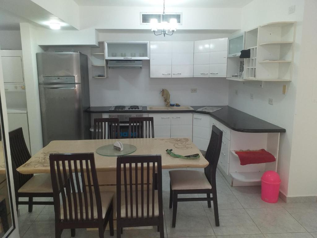 a kitchen with a table and chairs and a kitchen with a refrigerator at Apartamento equipado frente de la bahía de pampatar in Pampatar