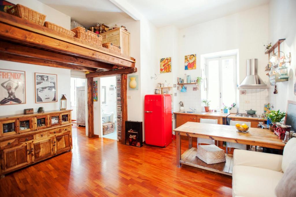 een keuken met een tafel en een rode koelkast bij A Secret Corner in Rome