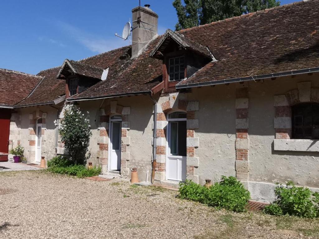 Huisseau-sur-CossonにあるGîte plain-pied avec terrasse et étang, proche Châteaux de la Loire - FR-1-491-354の赤い扉のある古い石造りの家