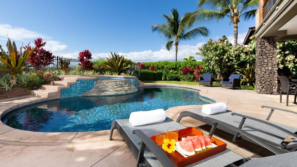 - une piscine avec une table et un plateau de fruits dans l'établissement DREAMS COME TRUE Dreamlike 3BR KaMilo Home with Amazing View and Pool, à Waikoloa