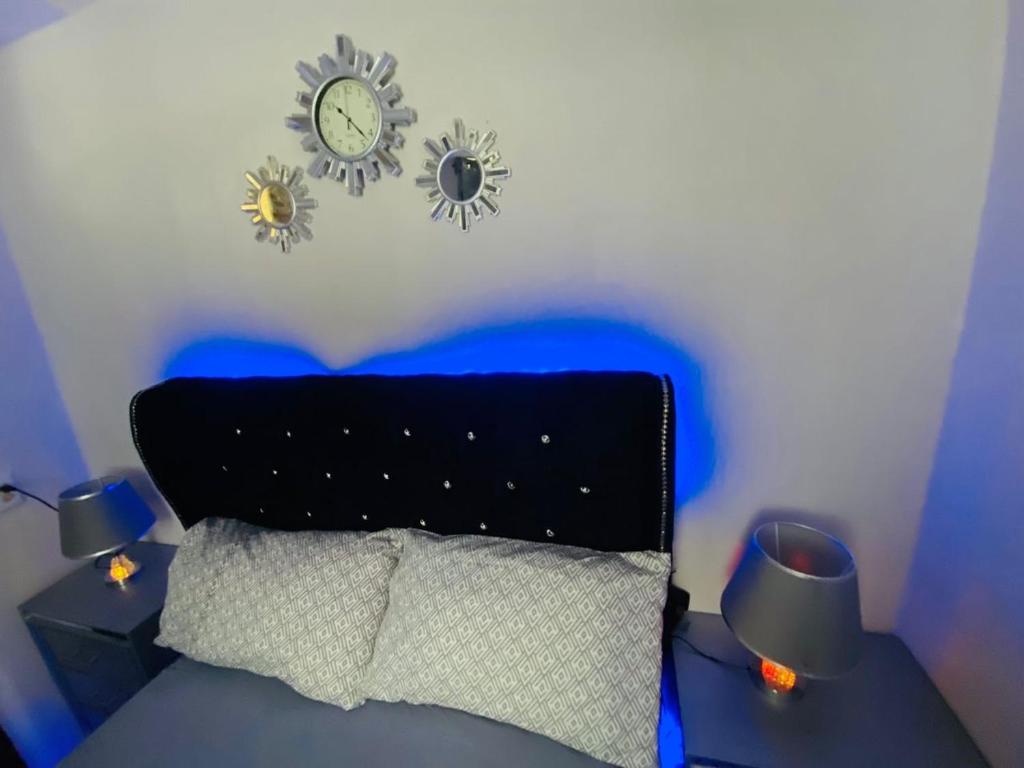 a bedroom with a bed with a clock on the wall at Juju House in Cap-Haïtien