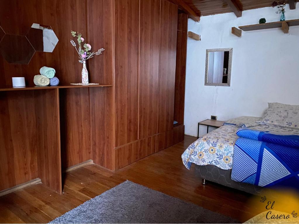 Un dormitorio con una cama y un jarrón con flores. en Acogedora y Céntrica Habitación - H. El Casero, en Cajamarca