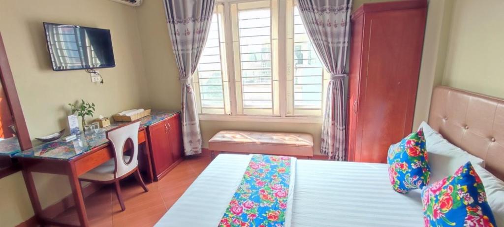 a bedroom with a bed and a desk and a window at khách sạn forever in Hanoi