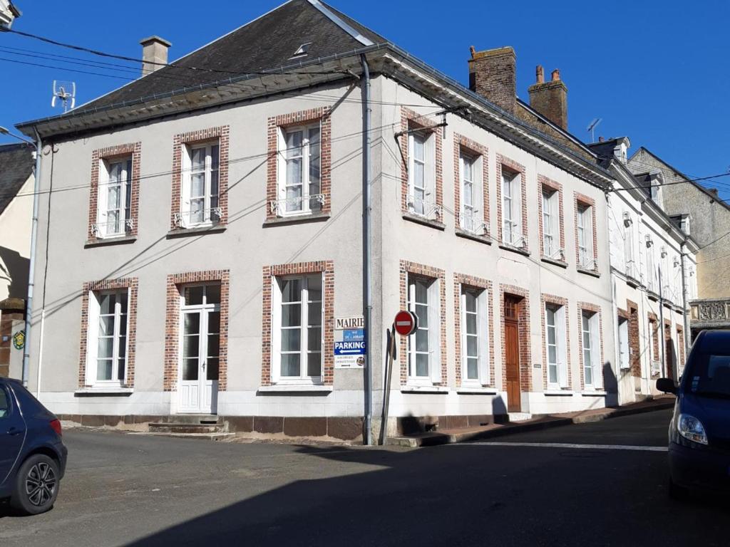 un edificio blanco con una señal de stop delante de él en Gîte Sargé-sur-Braye, 4 pièces, 6 personnes - FR-1-491-385, en Sargé-sur-Braye