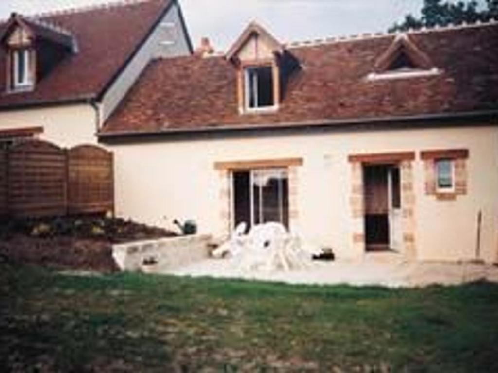 una casa blanca con un perro sentado en el patio en Gîte Cour-Cheverny, 2 pièces, 2 personnes - FR-1-491-387, en Cour-Cheverny