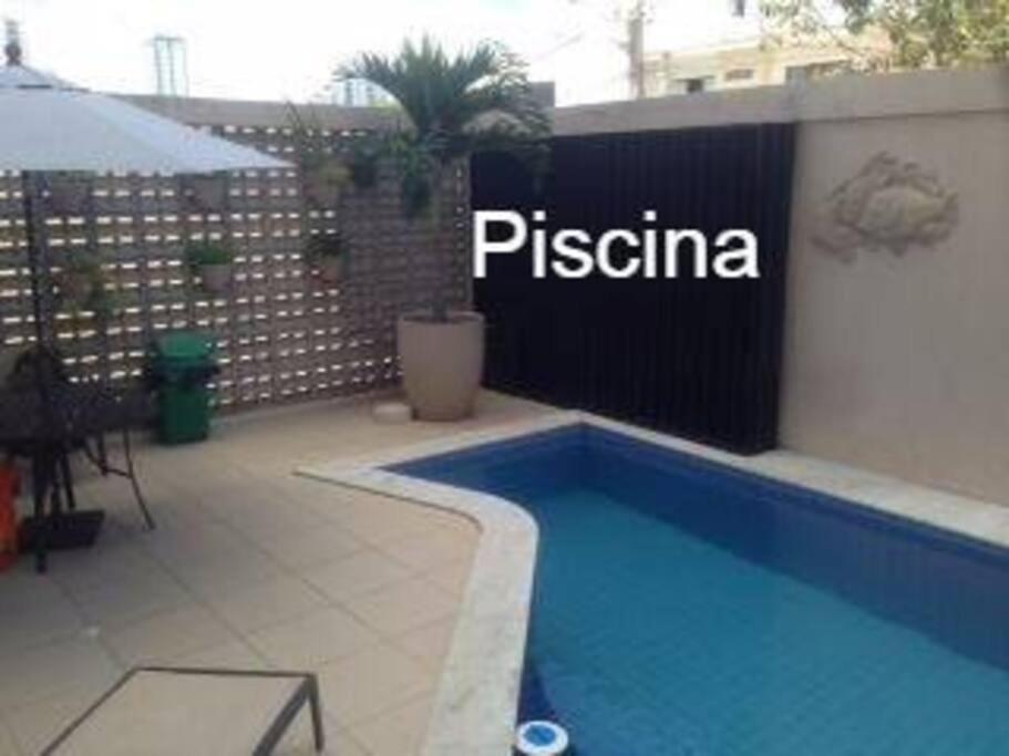 a swimming pool with a piscina sign on a building at Apartamento Caruaru PE bairro Mauricio de Nassau in Caruaru