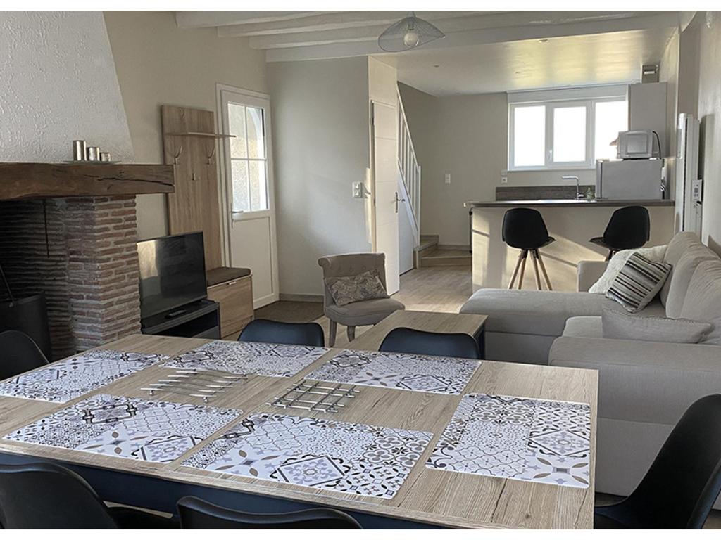 een woonkamer met een tafel en een woonkamer met een bank bij Gîte Avaray, 4 pièces, 6 personnes - FR-1-491-401 in Avaray