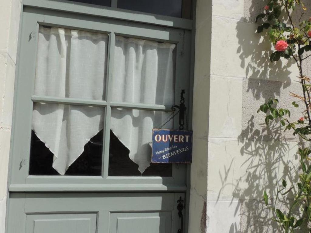 Una puerta con una ventana con un cartel. en Gîte Couddes, 3 pièces, 6 personnes - FR-1-491-411, en Couddes