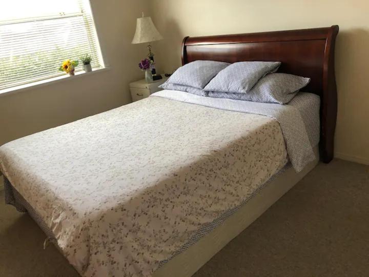 uma cama com uma cabeceira em madeira num quarto em Cozy 1 bedroom 1 bath guest suite in a house em Burnaby