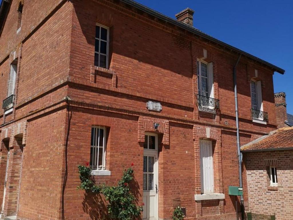 a red brick building with a white door and windows at Ancienne maison de maître rénovée, 6 pers, au cœur de la Sologne avec cour fermée et équipements modernes - FR-1-491-412 in Souvigny-en-Sologne