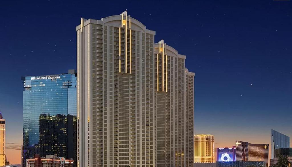a tall building with lights on it in a city at The Signature MGM by Orgoto in Las Vegas