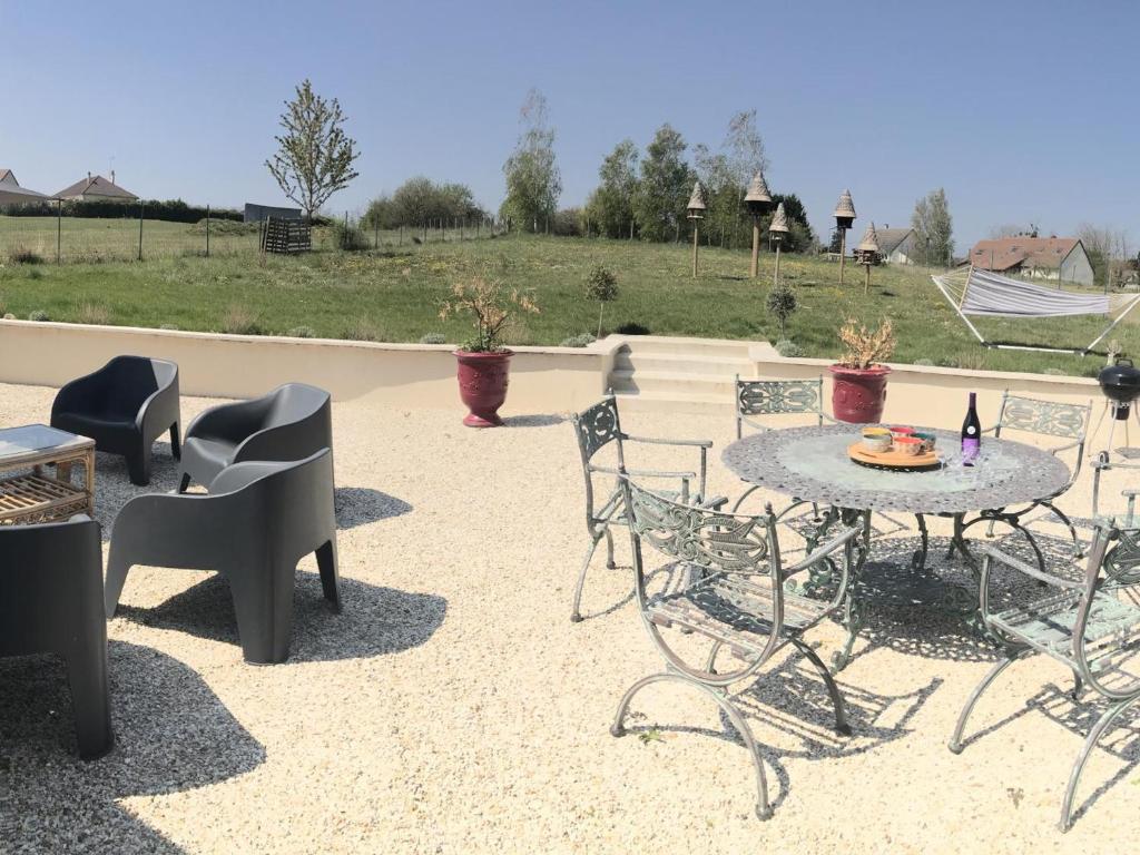 d'une terrasse avec des chaises, une table, une table et des chaises. dans l'établissement Gîte familial de plain-pied avec grande terrasse, jardin clos et équipements complets à Vallières-les-Grandes - FR-1-491-423, à Vallières-les-Grandes