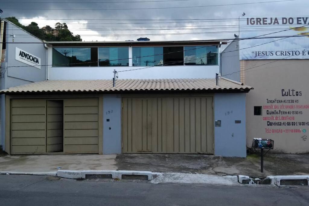 a building with two garage doors in front of it at Apto individual com Garagem próx Petrobrás e Fiat in Betim