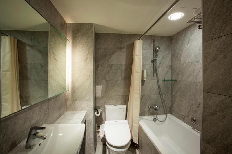 a bathroom with a toilet and a sink and a shower at Citizen Hotel in Taipei