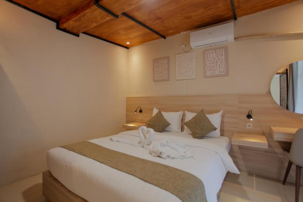 a bedroom with a large white bed with wooden ceilings at La Berza Resort in Subang