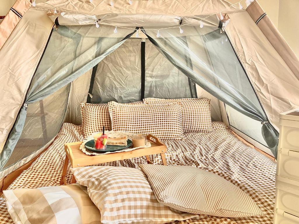 a bed with a table in a tent at Condo Glamping at Vinia in Manila