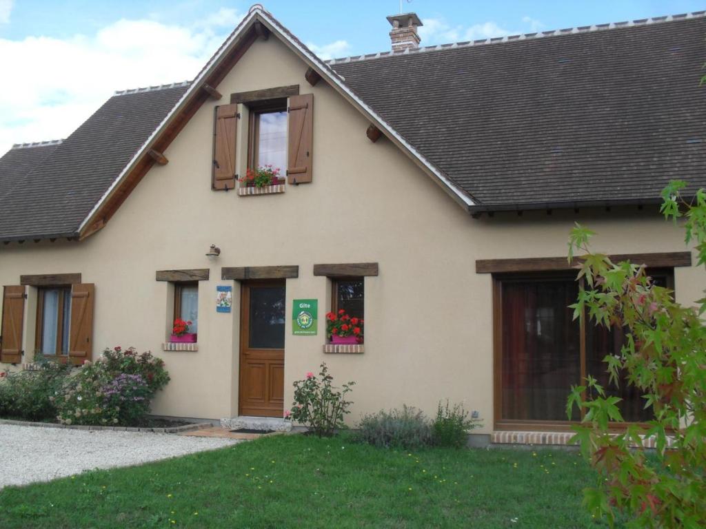 a house with flower boxes on the windows at Maison spacieuse en Sologne avec grand jardin, proche randonnée, terrasse, parking privé - FR-1-491-437 in Chaon