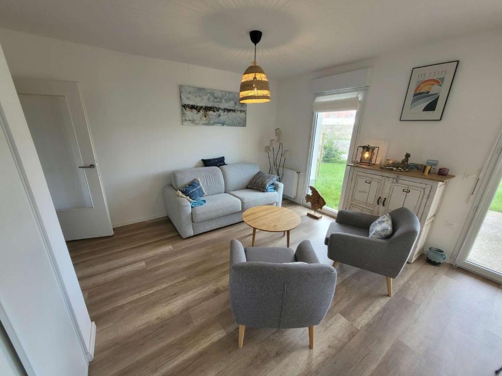 un salon avec un canapé, des chaises et une table dans l'établissement Bel appartement moderne avec jardin et parking privatif - FR-1-675-38, à Wimereux