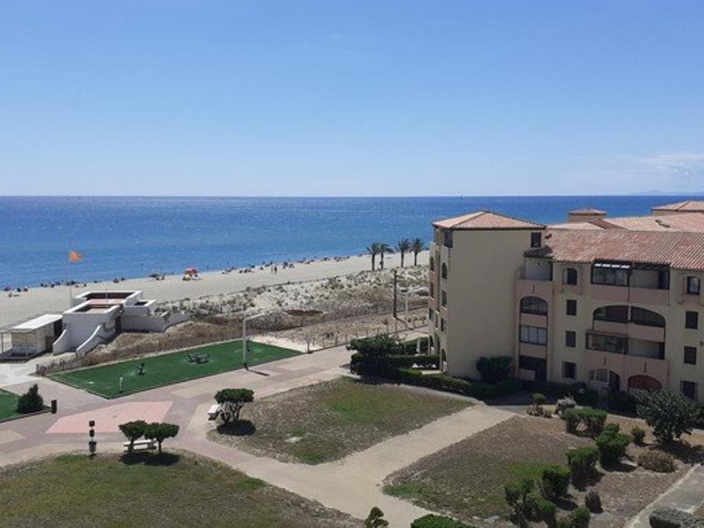 - une vue sur un bâtiment et la plage dans l'établissement Appart rénové en bord de mer, ascenseur, parking, 50m plage - FR-1-782-49, au Barcarès