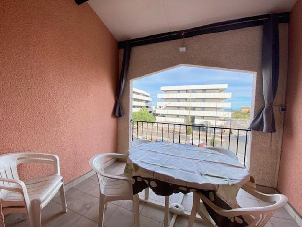 Cette chambre dispose d'une table, de chaises et d'un balcon. dans l'établissement Appartement 2 pièces proche plage et commerces, 4 pers, Barcares - FR-1-782-47, au Barcarès