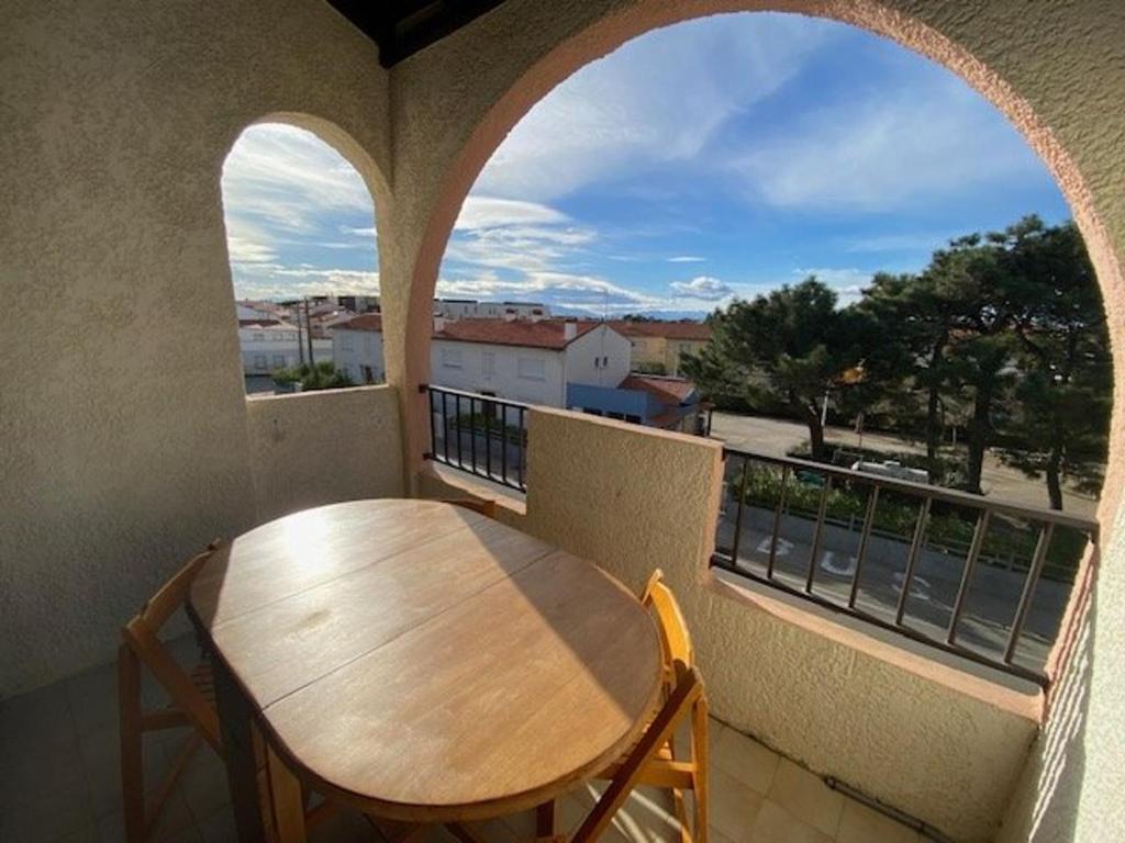 une table et des chaises sur un balcon avec une fenêtre dans l'établissement Appartement T2 Mezzanine avec Terrasse, Piscine, Proche Plage et Commerces - Le Barcarès Village - FR-1-782-48, au Barcarès