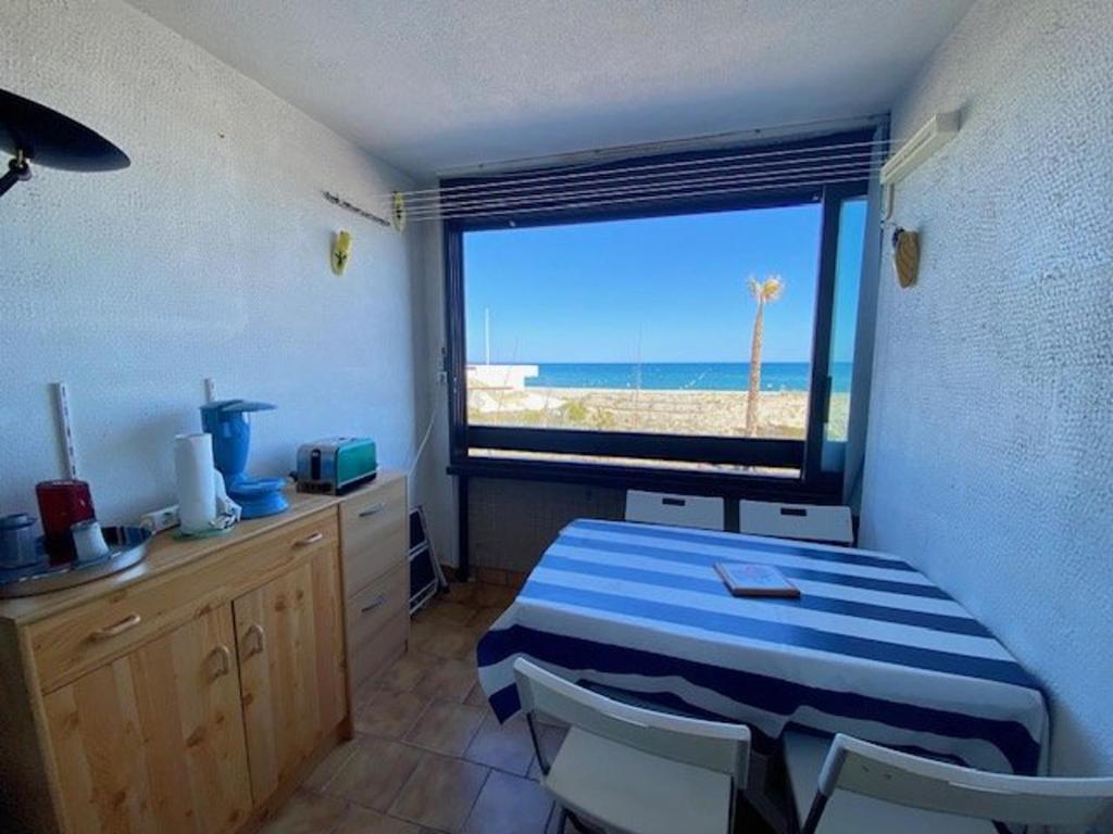 een kamer met een tafel en uitzicht op het strand bij Appartement Le Barcarès, 2 pièces, 4 personnes - FR-1-782-50 in Le Barcarès